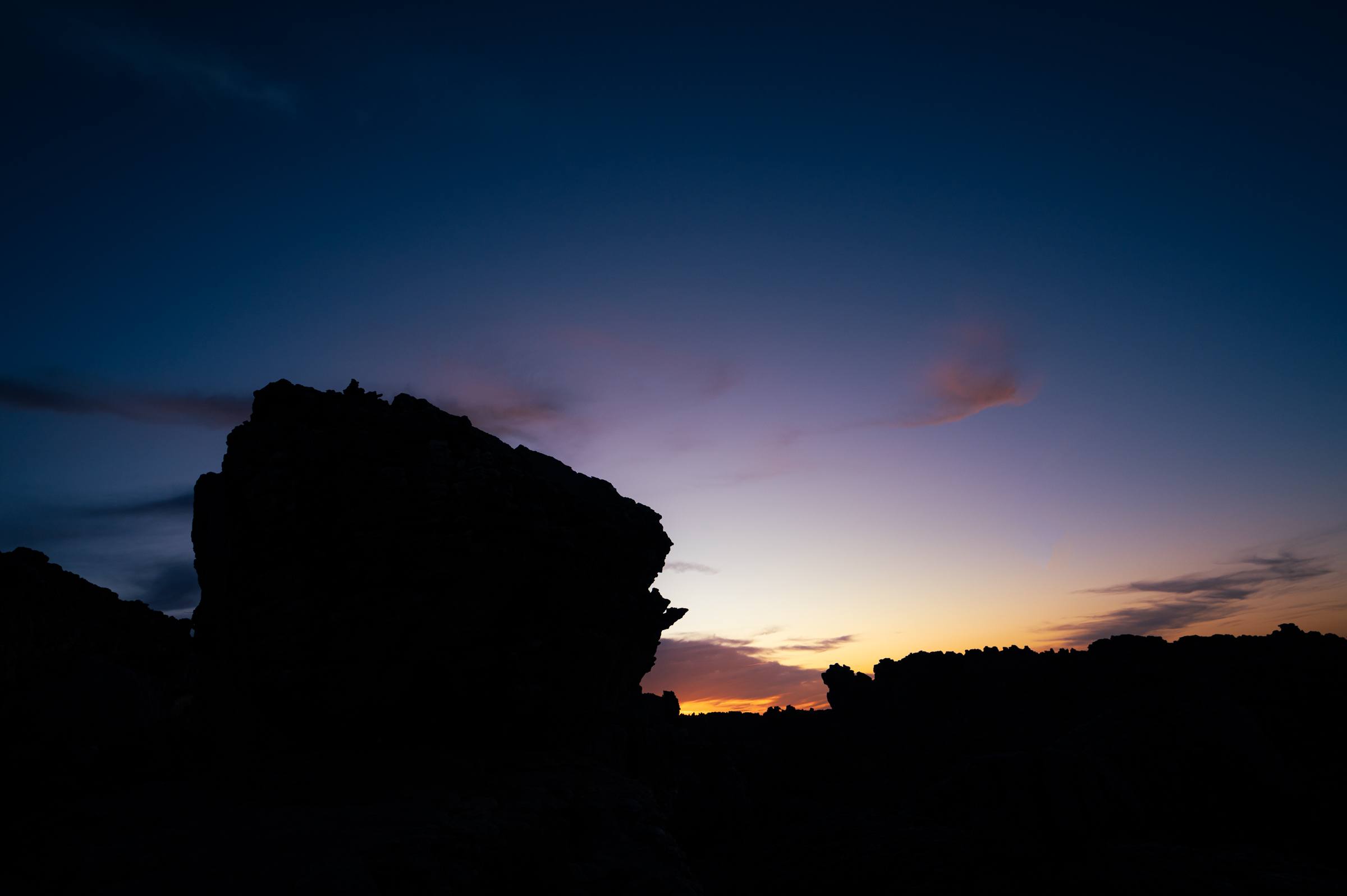A Rocklands boulder silhouetted against a purple and orange twilight sky over the Cederberg